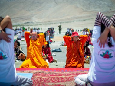 Ladakh, Hindistan - 23 Haziran 2022: Uluslararası Yoga Günü 'nde Pangong Gölü' nde yoga yapan Ladakhi halkı. Ladakh Hindistan 'ın en yüksek platosudur.