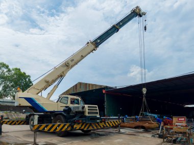 Taşınabilir vinçler, bölgeye taşınabilmesi için çatı kirişlerini kaldırıyor.