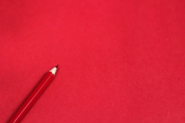 Kırmızı kağıda koyulan tahta kırmızı kalem renginin üst görünüm fotoğrafıyla kopyalama alanı olan şablon 