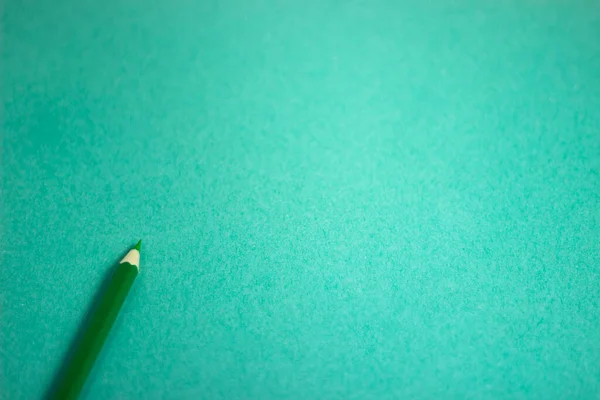 Yeşil kağıda konulan tahta yeşil kalem renginin üstten görünümü ile kopyalama alanı ile şablon 