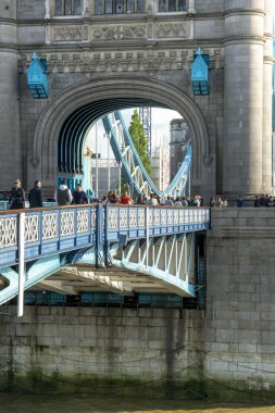 Londra, İngiltere - 7 Mayıs 2023: Londra 'daki Tower Bridge' de yürüyen insanlar. Kule Köprüsü 1886 ve 1894 yılları arasında inşa edildi. .
