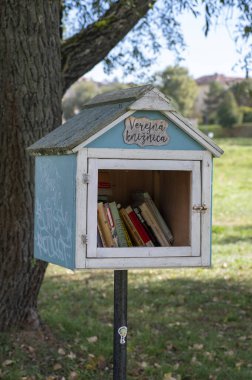 Zvolen, Slovakya - 8 Ekim 2023: Zvolen kentindeki bir banliyö parkında küçük ahşap kütüphane evi (Verejna Kniznica). Slovakya.