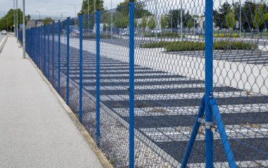 Korunan bölgenin etrafını saran mavi çelik tel örgü. Kısıtlı bölge koruması.