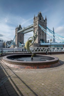 London, UK - March 21, 2024 : Girl with a Dolphin (1973) sculpture by David Wynne with Tower bridge and the Shard in the background. clipart
