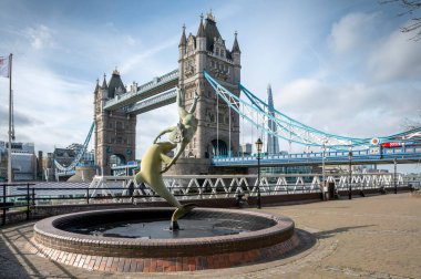 Londra, İngiltere - 21 Mart 2024: Dolphin 'li Kız (1973) heykeli: David Wynne' nin Tower Bridge 'li heykeli ve arka plandaki Çömlek.