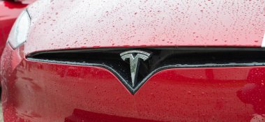Nitra, Slovakya - 4 Ekim 2024: su damlaları olan bir arabanın kaputunda Tesla damgası. Modern bir Tesla arabası. Tesla logo ayrıntıları.