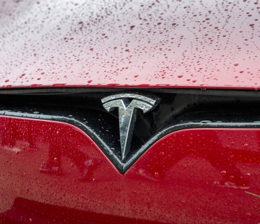 Nitra, Slovakya - 4 Ekim 2024: su damlaları olan bir arabanın kaputunda Tesla damgası. Modern bir Tesla arabası. Tesla logo ayrıntıları.