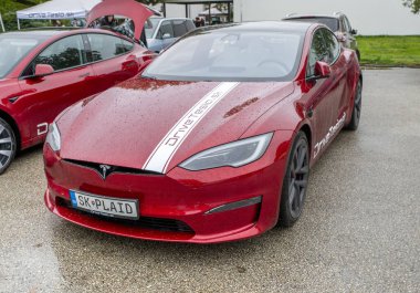 Nitra, Slovakya - 4 Ekim 2024: su damlaları olan bir arabanın kaputunda Tesla damgası. Modern bir Tesla arabası. Tesla logo ayrıntıları.