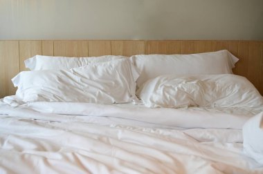 Beyaz yatak ve yastıklar odada.