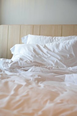 Beyaz yatak ve yastıklar odada.