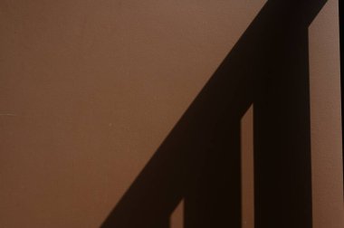 kahverengi duvar desenli arka plan ve korkuluk gölgesi