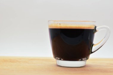 Bir bardak sade kahve, ahşap arka planda.