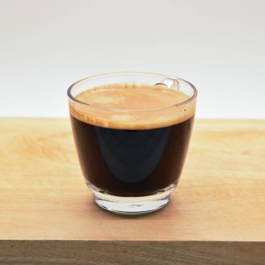 Bir bardak sade kahve, ahşap arka planda.