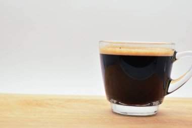 Bir bardak sade kahve, ahşap arka planda.