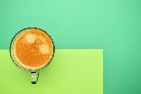 glass of hot black coffee put on green background