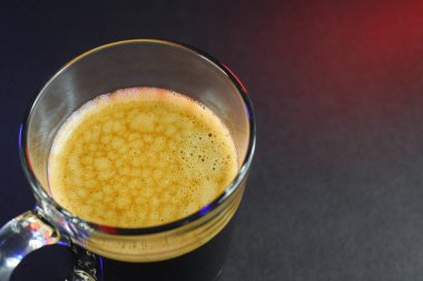 Siyah sehpanın üzerinde, neon ışıklı sıcak sade kahve.