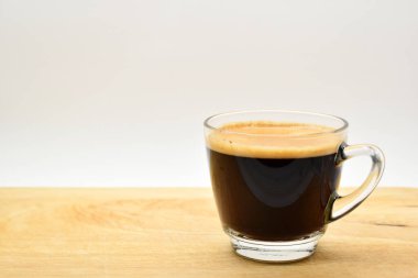 Bir bardak sade kahve, ahşap arka planda.