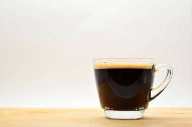 Bir bardak sade kahve, ahşap arka planda.