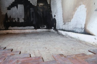 old scary interior burn house, cement wall and wood floor