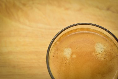 Bir bardak sade kahve, ahşap arka planda.