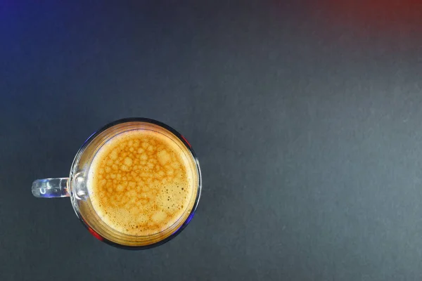 hot black coffee on black table with neon lights