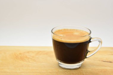 Bir bardak sade kahve, ahşap arka planda.