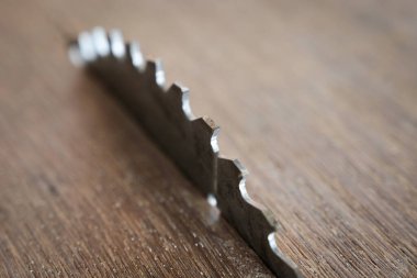 sharp metal saw on wood plank texture background, construction machine