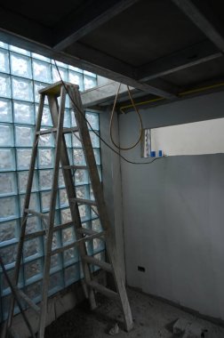 interior constuction site industry with glass block and steel ladder