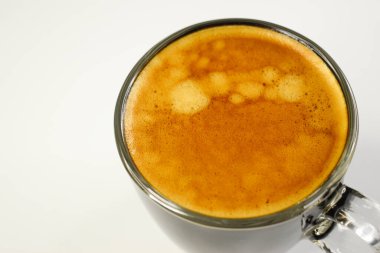 Sıcak siyah kahve beyaz masa arkasına konur.