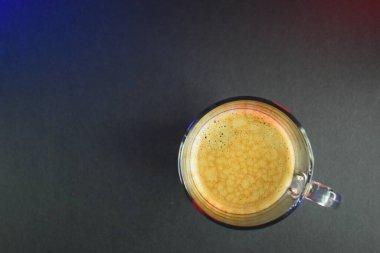 Siyah sehpanın üzerinde, neon ışıklı sıcak sade kahve.