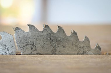Tahta döşeme arka planında keskin metal testeresi, inşaat makinesi.