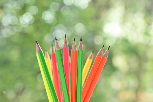 一组色彩斑斓的尖铅笔在模糊的绿色自然背景上与Bokeh — 图库照片