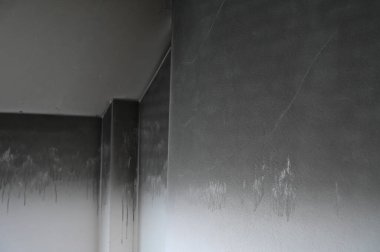 Ev yangından yanmış, siyah kirli duvar.