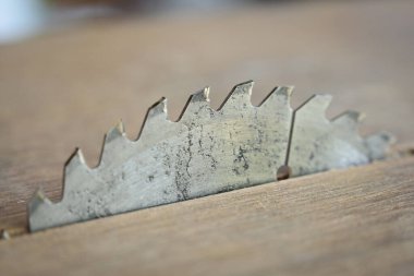 Tahta döşeme arka planında keskin metal testeresi, inşaat makinesi.