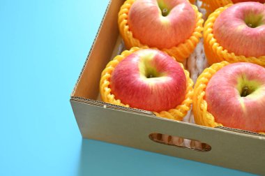 beautiful pink apple in the box on blue background