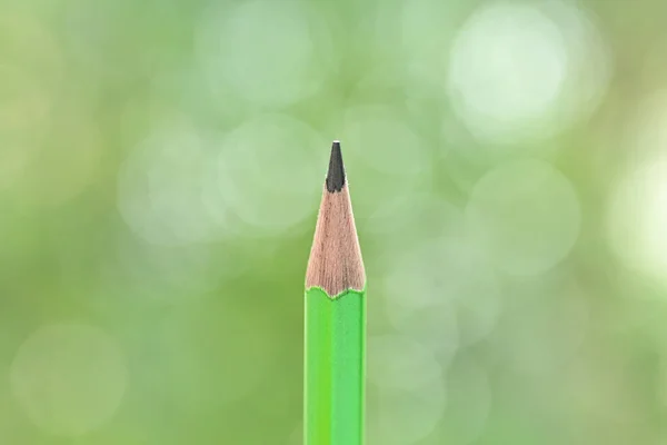 sharp green pencil on blur nature background with bokeh
