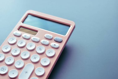 Modern şeftali rengi hesap makinesini kapat ve mavi arkaplanda beyaz düğme, iş ve finans muhasebe kavramını kapat
