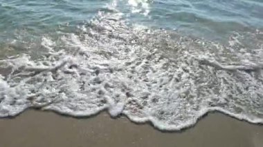 Kumsalda deniz dalgaları, güzel güneş ışığı sabah tatilinde parlıyor.