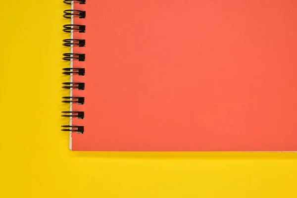 Stock image orange notebook on yellow background, stationery for office