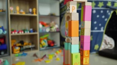 Küçük çocuk birçok renkli ahşap bloktan bir şehir inşa ediyor. Tasarım için yaratıcı bir oyuncak.