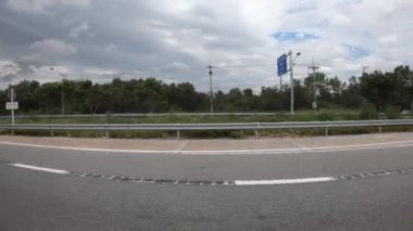 Ağaçların çevresindeki manzaralı yolda araba sürmek, kırsal alanda 4K.