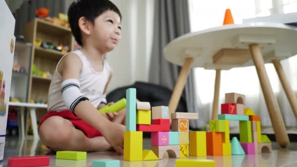 小男孩用许多五彩斑斓的木块建造了一座城市 为设计提供了创意玩具 — 图库视频影像
