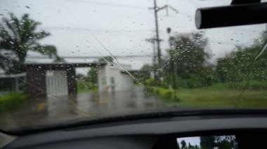 Yavaş çekim sahnesi, yağmurlu bir günde araba sürmek, cam silecekleri temiz yağmur damlaları.