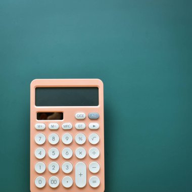 modern şeftali rengi hesap makinesi ve yeşil arka planda beyaz düğme, iş ve finans muhasebe kavramı