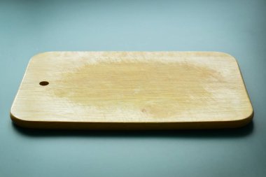 Yeşil arka planda kahverengi ahşap kesim tahtası, mutfakta yemek pişirmek için ekipman.