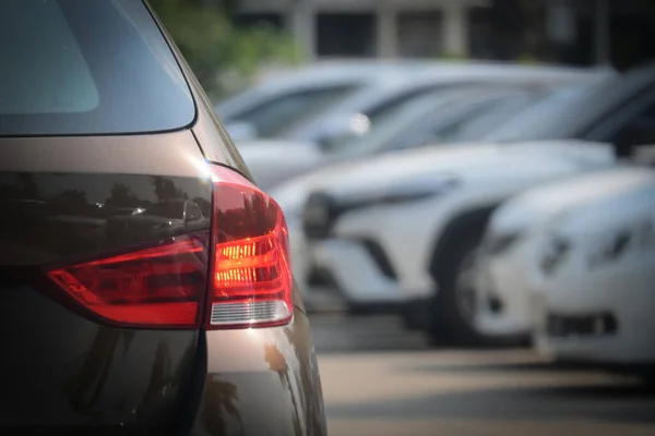 大型アスファルト駐車場交通産業における茶色の車の赤いテールライト ロイヤリティフリーのストック画像