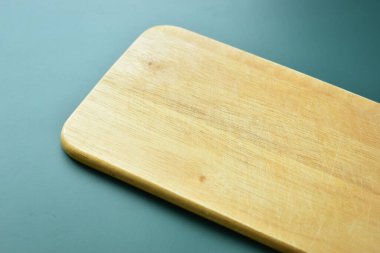 Yeşil arka planda kahverengi ahşap kesim tahtası, mutfakta yemek pişirmek için ekipman.