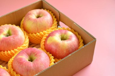 beautiful pink apple in the box on pink background