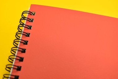 Sarı arkaplanda turuncu defter, ofis için kırtasiye malzemesi