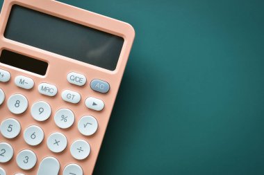 modern şeftali rengi hesap makinesi ve yeşil arka planda beyaz düğme, iş ve finans muhasebe kavramı